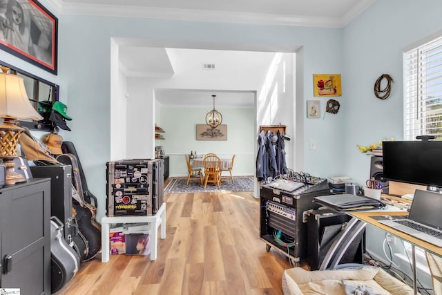 home office with a chandelier, crown molding, visible vents, and light wood-type flooring