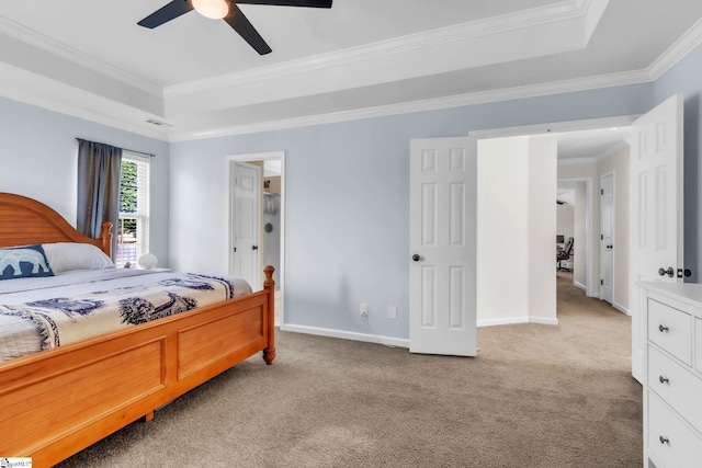 bedroom featuring baseboards, a raised ceiling, a ceiling fan, crown molding, and light colored carpet