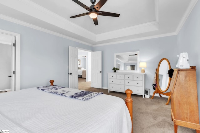 carpeted bedroom featuring ornamental molding, baseboards, a raised ceiling, and ceiling fan