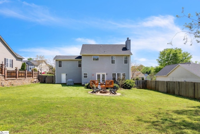 back of house with a yard, a fenced backyard, and a chimney