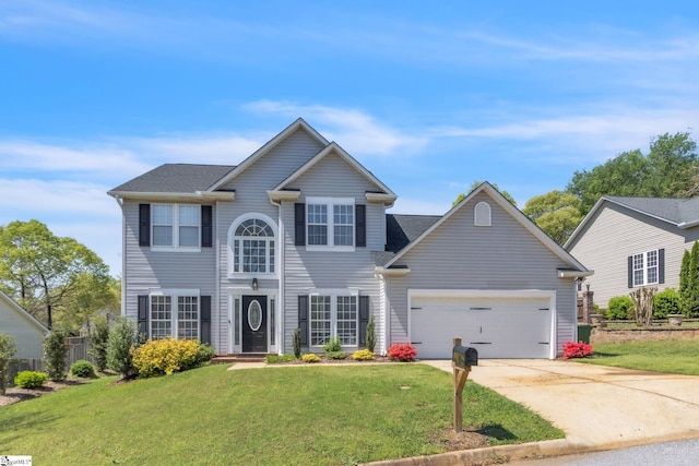 view of front of property featuring a front yard, driveway, and an attached garage