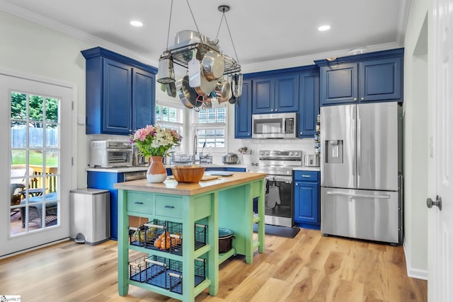 kitchen with crown molding, tasteful backsplash, a chandelier, appliances with stainless steel finishes, and blue cabinets