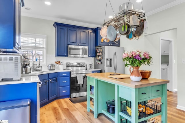 kitchen with crown molding, light wood-type flooring, appliances with stainless steel finishes, butcher block countertops, and backsplash