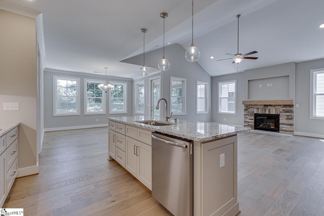kitchen featuring light wood-style flooring, ceiling fan with notable chandelier, stainless steel dishwasher, and a sink