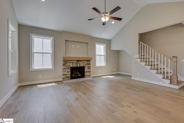 unfurnished living room featuring a ceiling fan, vaulted ceiling, wood finished floors, stairs, and baseboards