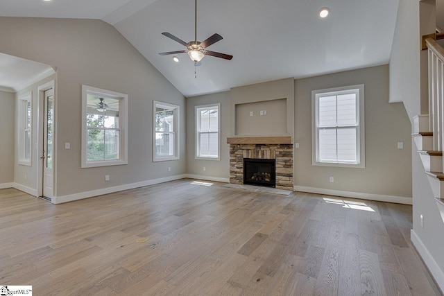 unfurnished living room with light wood-style flooring, ceiling fan, plenty of natural light, and vaulted ceiling