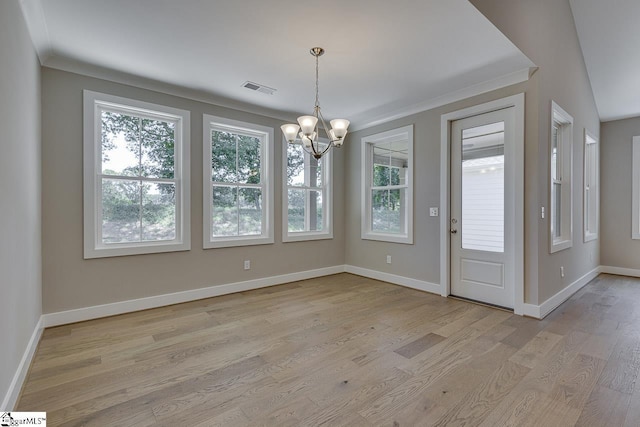 interior space featuring a notable chandelier, baseboards, ornamental molding, light wood-style flooring, and visible vents