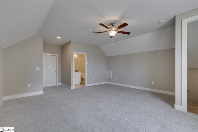 additional living space with lofted ceiling, visible vents, baseboards, and ceiling fan