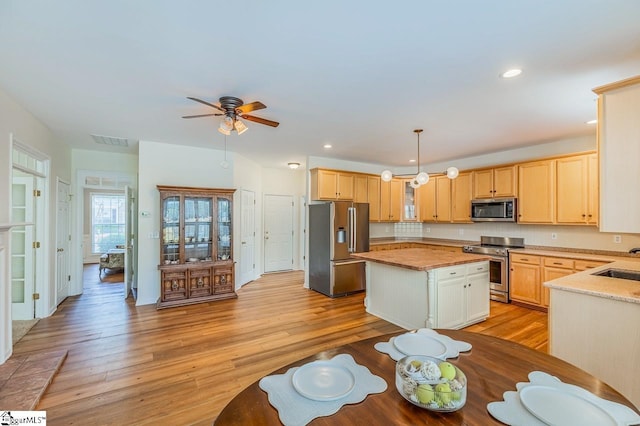 kitchen with visible vents, a center island, appliances with stainless steel finishes, and light wood finished floors