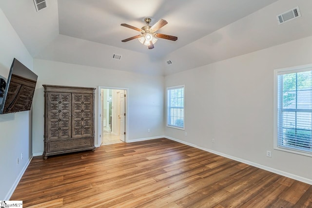 unfurnished bedroom with visible vents, multiple windows, and wood finished floors