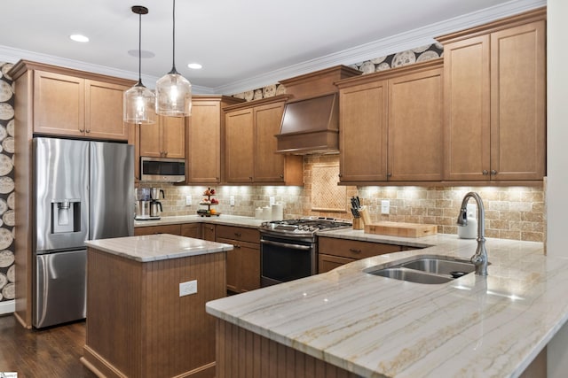 kitchen with a peninsula, premium range hood, light stone countertops, appliances with stainless steel finishes, and a sink