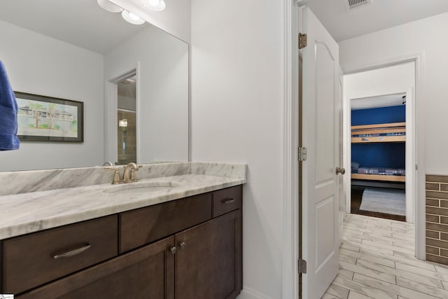 bathroom featuring visible vents, a shower, and vanity