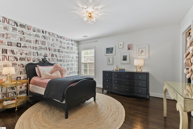 bedroom featuring wood finished floors, baseboards, and visible vents