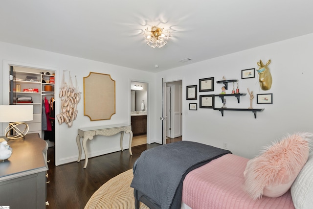 bedroom featuring a closet, baseboards, ensuite bath, dark wood-style floors, and a walk in closet