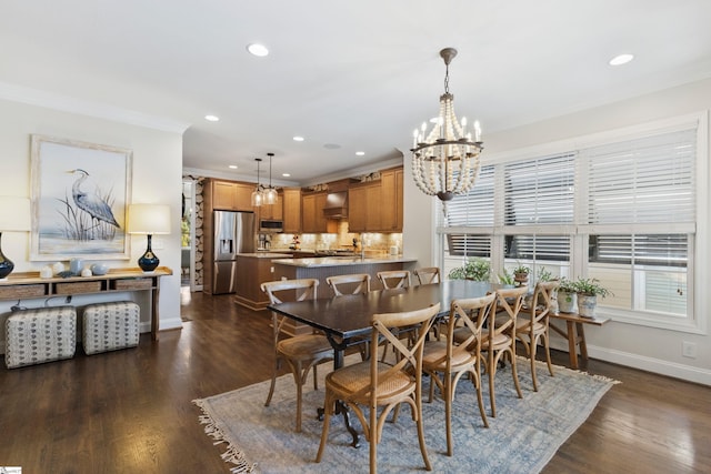 dining area featuring a notable chandelier, dark wood-style flooring, and ornamental molding
