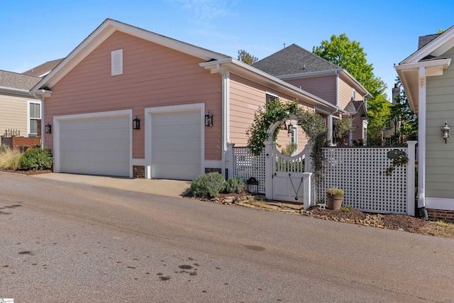view of front of property with a garage, driveway, and a gate