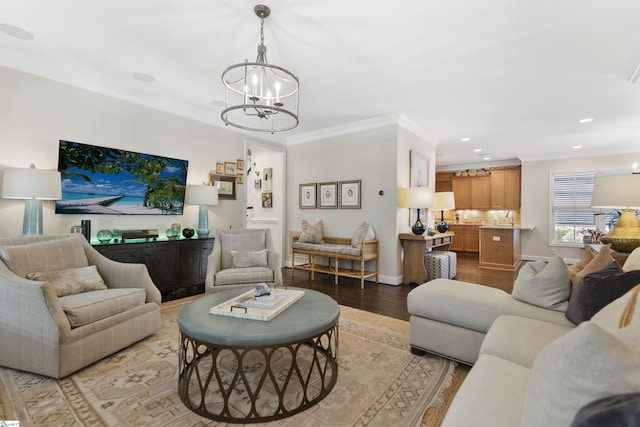 living area with baseboards, a chandelier, crown molding, light wood finished floors, and recessed lighting