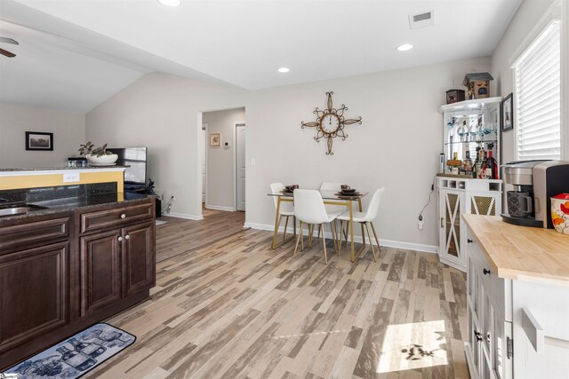 122 Barred Owl Dr, Fountain Inn, SC 29644 - kitchen with dark brown cabinetry, baseboards, vaulted ceiling, light wood-style flooring, and wooden counters