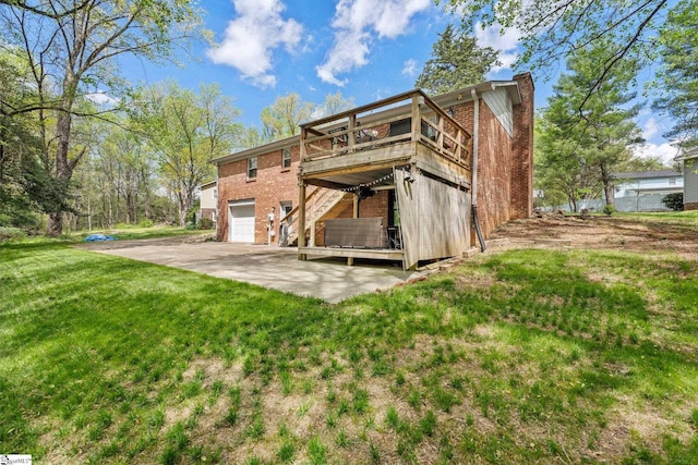 rear view of house featuring brick siding, an attached garage, a wooden deck, and a lawn