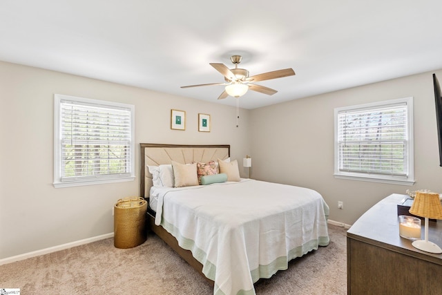 bedroom featuring light colored carpet, baseboards, and ceiling fan