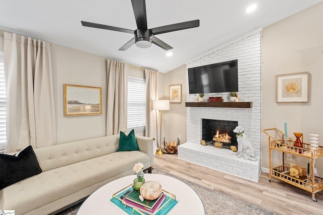 living area featuring vaulted ceiling, a fireplace, recessed lighting, ceiling fan, and wood finished floors