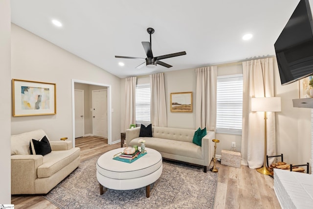 living area featuring lofted ceiling, wood finished floors, and ceiling fan
