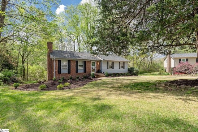 ranch-style home with a chimney, a front yard, and brick siding