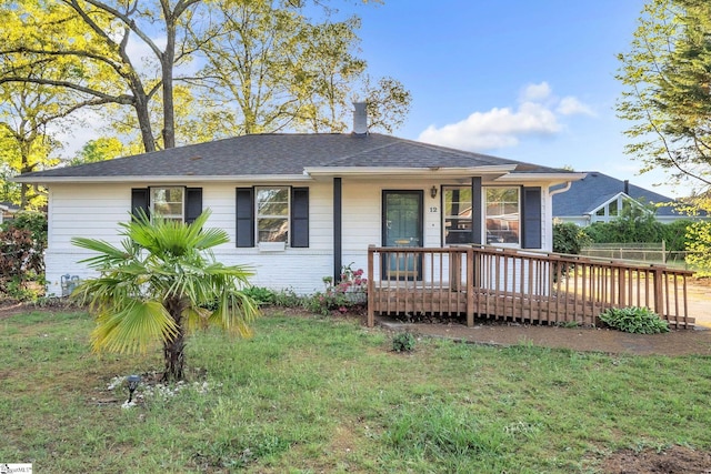 view of front of home featuring roof with shingles and a front lawn