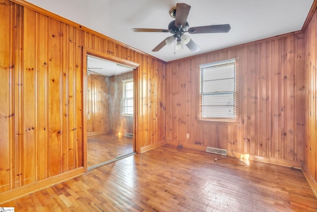 empty room featuring wood-type flooring, baseboards, and a ceiling fan