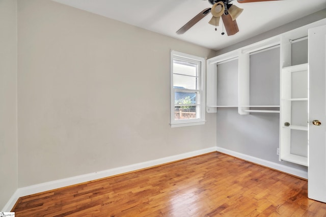 interior space featuring ceiling fan, baseboards, and wood finished floors