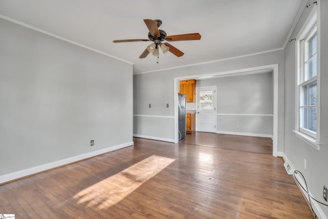 unfurnished room with dark wood-type flooring, ornamental molding, baseboards, and ceiling fan