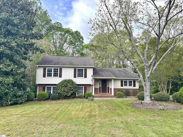tri-level home with brick siding and a front yard