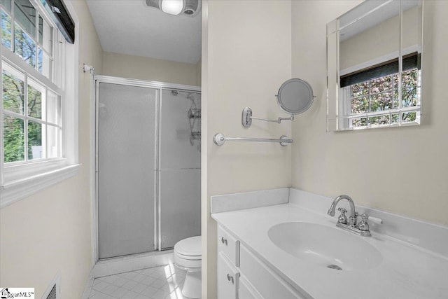 bathroom featuring toilet, tile patterned flooring, and a healthy amount of sunlight