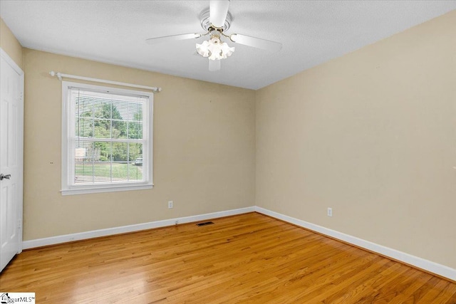 spare room featuring light wood-style floors, baseboards, and visible vents
