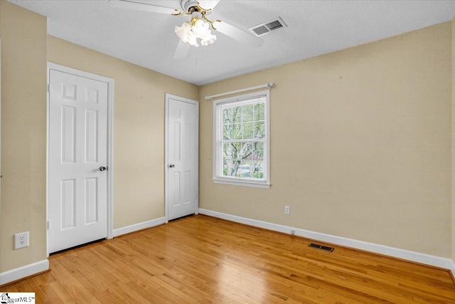 unfurnished bedroom featuring light wood-style floors, visible vents, and baseboards