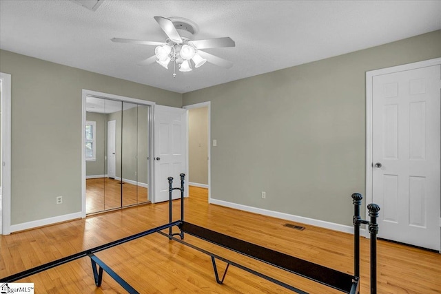 unfurnished bedroom with visible vents, baseboards, a closet, ceiling fan, and light wood finished floors