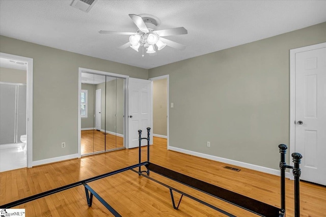 unfurnished bedroom featuring a closet, light wood finished floors, visible vents, and baseboards