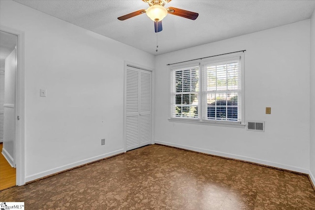 empty room featuring visible vents, ceiling fan, baseboards, and a textured ceiling