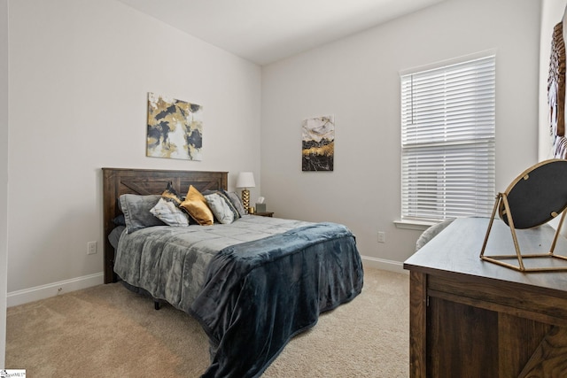 bedroom featuring light colored carpet and baseboards