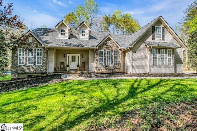 cape cod home featuring a shingled roof, stone siding, and a front lawn
