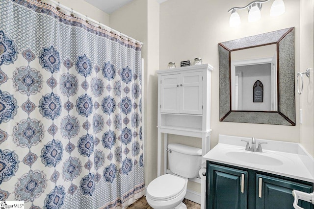 bathroom with toilet, curtained shower, and vanity