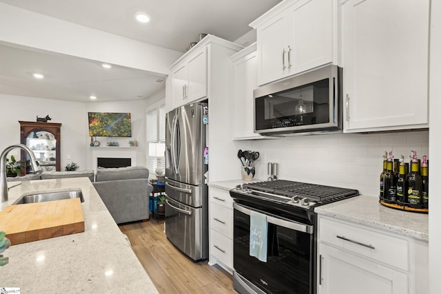 17 Starlake Rd, Simpsonville, SC 29681 - kitchen featuring light wood-style flooring, white cabinets, a sink, stainless steel appliances, and open floor plan