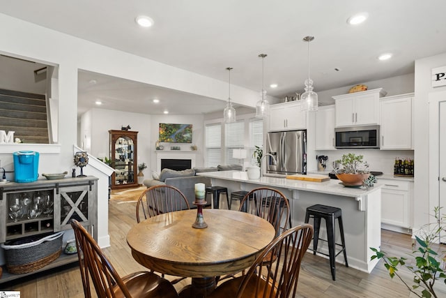 17 Starlake Rd, Simpsonville, SC 29681 - dining space featuring stairway, recessed lighting, light wood finished floors, and a fireplace