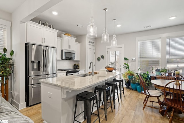 17 Starlake Rd, Simpsonville, SC 29681 - kitchen with light wood-style flooring, visible vents, decorative backsplash, stainless steel appliances, and a sink