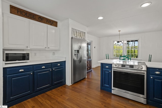 kitchen with dark wood-style flooring, light countertops, blue cabinetry, white cabinets, and stainless steel appliances