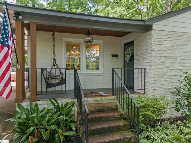 property entrance with brick siding and covered porch
