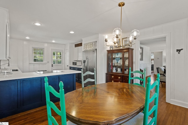 dining area with a chandelier, recessed lighting, and dark wood-style flooring
