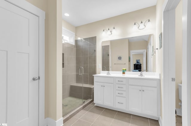 full bath featuring double vanity, tile patterned floors, toilet, a shower stall, and a sink