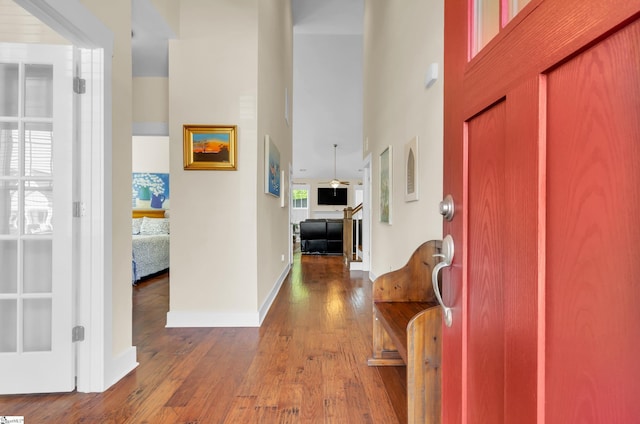 entrance foyer featuring a high ceiling, wood-type flooring, and baseboards