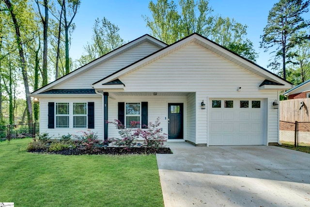 view of front of house featuring a front yard, an attached garage, fence, and driveway